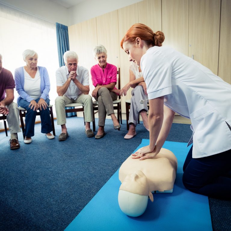 Nurse teaching first aid to a group of seniors