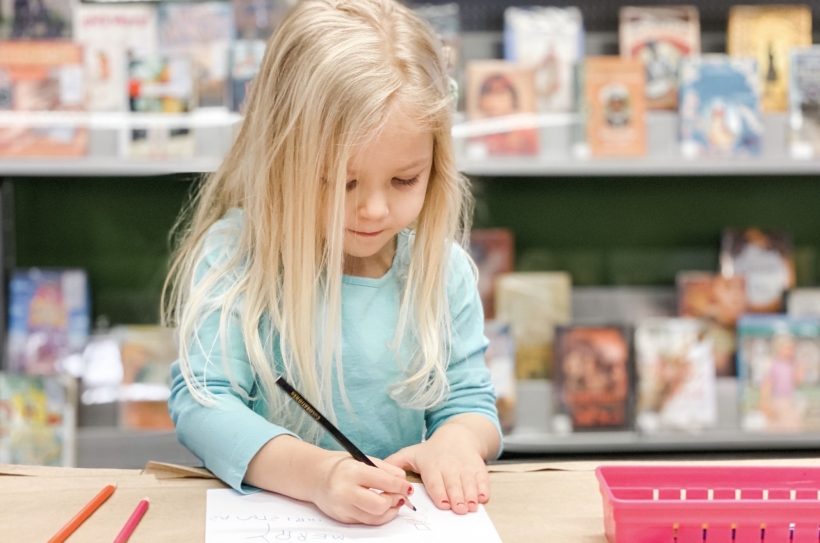 Preschool age girl writing a homemade card - crafts