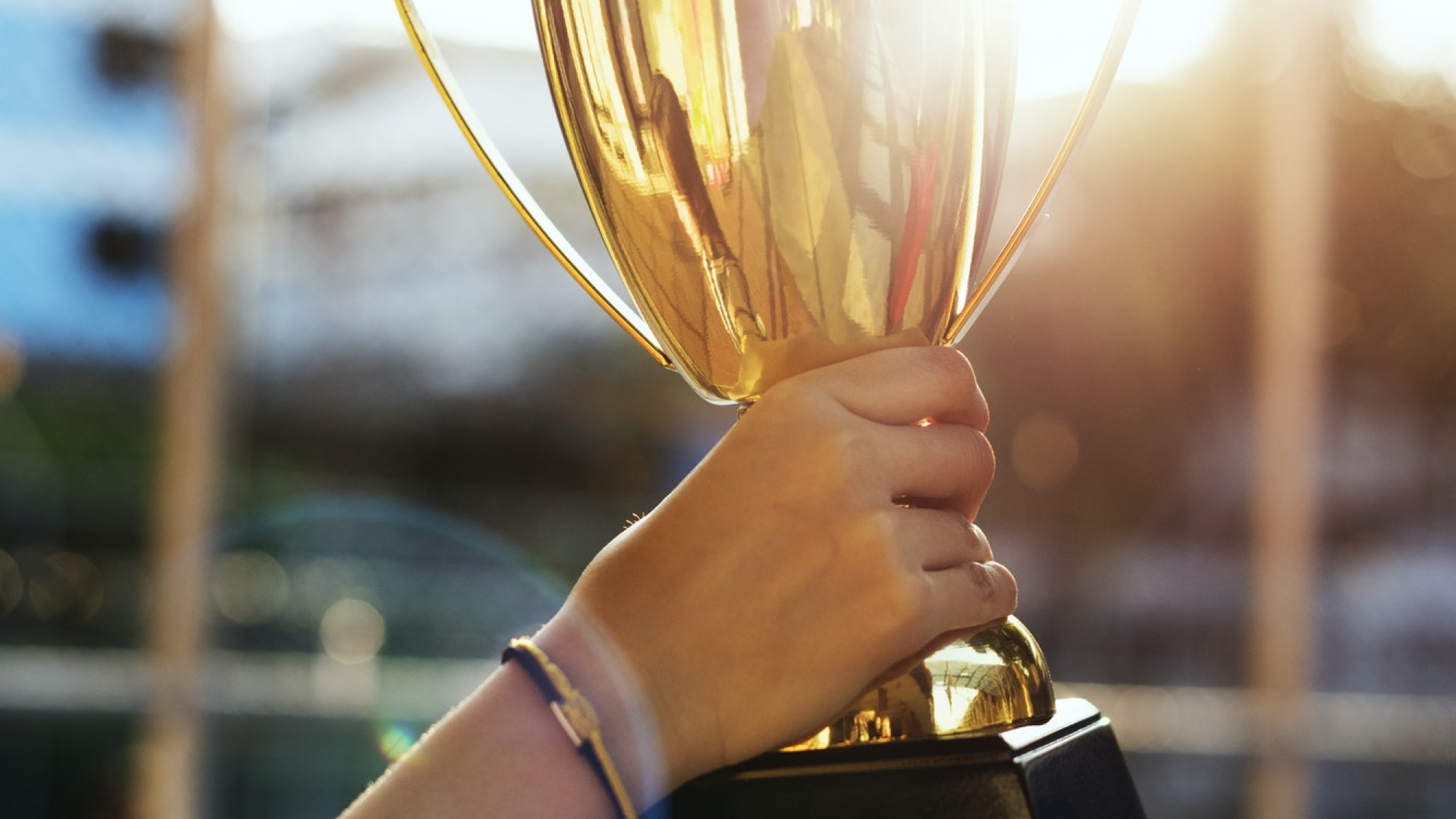 Feminine hand holding a trophy outdoors